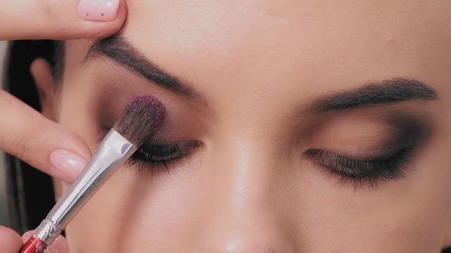 Professional stylist make-up artist makes eye makeup model