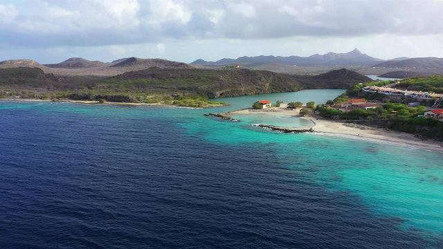 Aerial view of coast of Curaçao in the Caribbean Sea with turquoise water, cliff, beach and beautiful coral reef around the Sta. Martha Bay