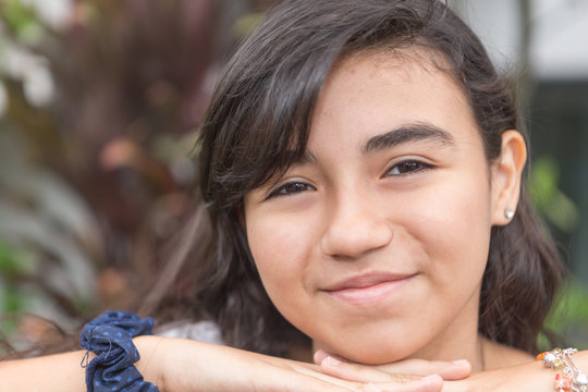 Little Teenager gil in a closeup portrait. She is smiling.