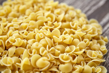 Funghetti pasta. Uncooked italian pasta on brown wooden table, closeup