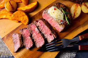 rustic medium butter beef steak with herbs and potato wedges