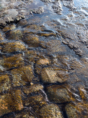 The flow of water on the pavement. Stones and water. Can be used as background.