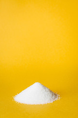 Heap of sugar on yellow background