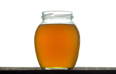 Round glass jar with freshly prepared ghee butter. On a white background.