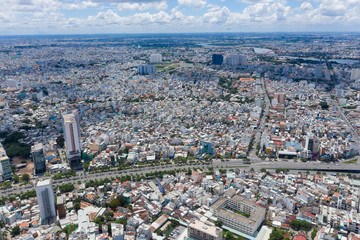 Fototapeta na wymiar Top View of Building in a City - Aerial view Skyscrapers flying by drone of Ho Chi Mi City with development buildings, transportation, energy power 