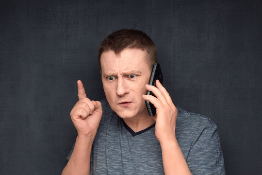 Portrait of angry man speaking on phone