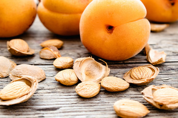 Apricot and apricot seeds on the background of old boards. Apricot pits for the manufacture of tablets and drugs.