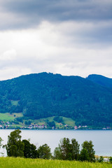 Calm cloudy day on lakefront of Attersee with mountains in background in late summer. lake Attersee in the Austrian Salzkammergut