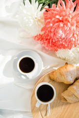Two black coffee and croissants on a white bed. Breakfast concept