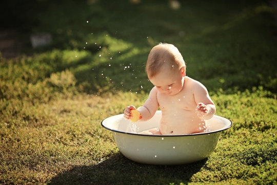 Little girl bathes in a basin