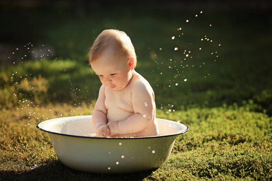 Little girl bathes in a basin