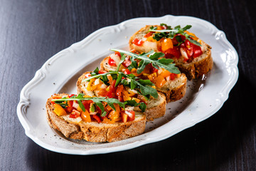 Bruschettas on plate on wooden background