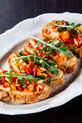 Bruschettas on plate on wooden background
