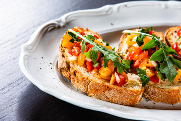 Bruschettas on plate on wooden background
