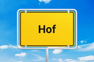 Stadt Hof. Gelbes Schild, Ortsschild, Ortseingangsschild. Himmel mit Wolken.