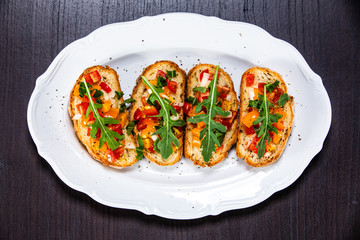 Bruschettas on plate on wooden background