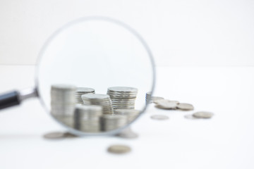 Stack of coins through magnifying glass. Save money. Business Finance concept