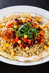 Groats with sauce and vegetables on tortilla