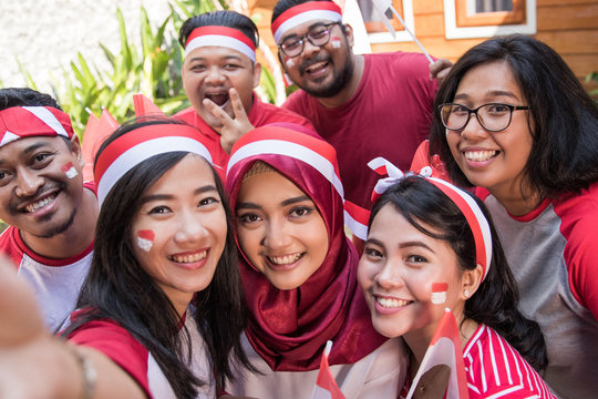 happy asian people celebrating indonesia independence day taking selfie