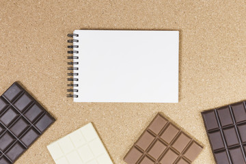 Top view chocolate bars with notebook