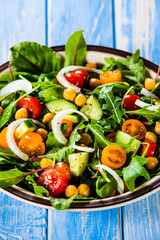 Greek salad with chickpea on wooden background