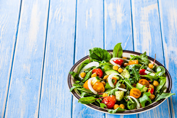 Greek salad with chickpea on wooden background