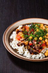 Rice with chickpea and vegetables on wooden table