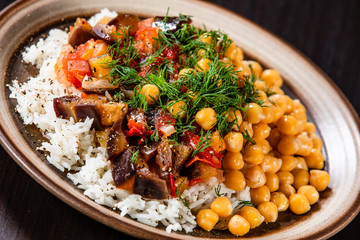 Rice with chickpea and vegetables on wooden table