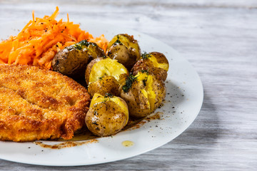 Fried pork chop, boiled potatoes and vegetable salad