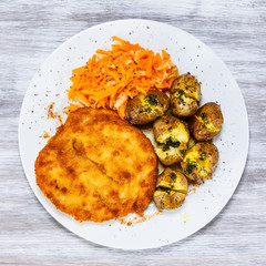 Fried pork chop, boiled potatoes and vegetable salad