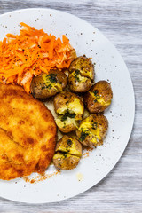 Fried pork chop, boiled potatoes and vegetable salad