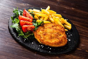 Fried pork chop, French fries and vegetables