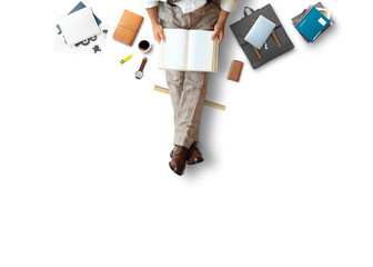 Young man sitting and working on floor with book and laptop, business concept