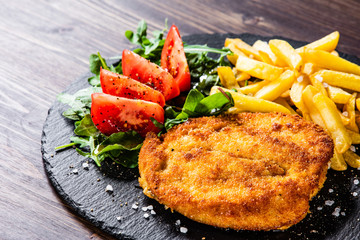 Fried pork chop, French fries and vegetables