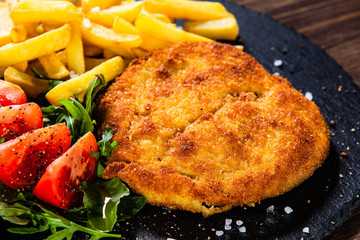 Fried pork chop, French fries and vegetables