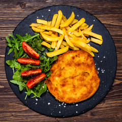 Fried pork chop, French fries and vegetables