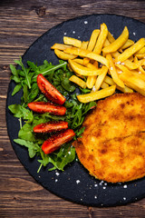 Fried pork chop, French fries and vegetables