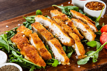 Fried pork chop and vegetable salad on cutting board