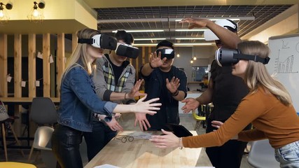Team of young business man and woman having business meeting using vr virtual reality glasses in the modern office. - Powered by Adobe
