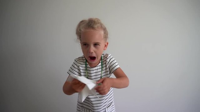 Little girl blow nose and get snotty face. Mother helping daughter clean face