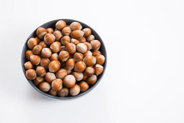 Hazelnut nuts in bowl, isolated white background