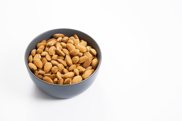 Almond nuts in bowl, isolated white background
