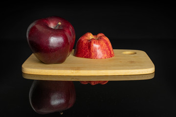 Group of one whole one half of fresh apple red delicious on a bamboo cutting board isolated on...