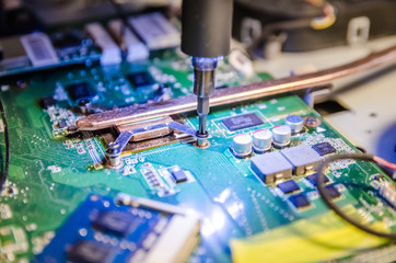 Technical support worker unspins the cover of the computer monoblock with a screwdriver with backlight