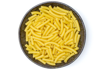Lot of whole raw pasta macaroni on grey ceramic plate flatlay isolated on white background