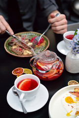 Breakfast table setting with pancakes, tea. Couple is eating