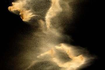 Sand explosion isolated on black background. Freeze motion of sandy dust splash.