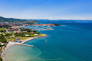 Fototapeta na wymiar Aerial view of seashore with rocks and building and green coastline area