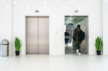 Teenager boy with casual clothes and white sneakers enters in elevator. © Deyan Georgiev