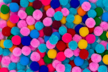 A colorful of Pom Pom background, top view colorful pom poms background.